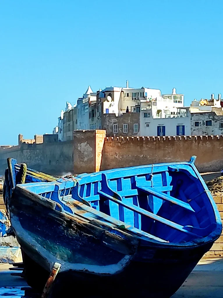 Blue fishing boat in front of the Essaouira medina walls