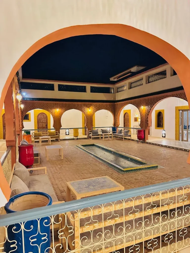 Photos Patio et bassin du riad la nuit, vus sous une arche